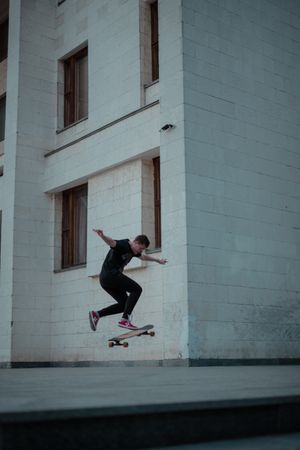 Man skate boarding beside a building