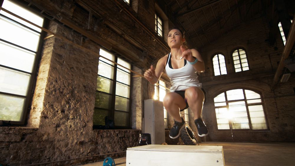 Fit Athletic Woman Does Box Jumps in the Deserted Factory Gym.