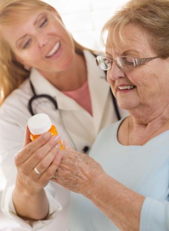 Female Doctor or Nurse Explaining Prescription to Older Adult Woman