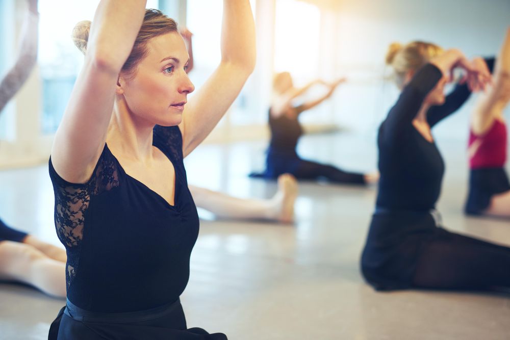 Woman stretching on floor of dance studio