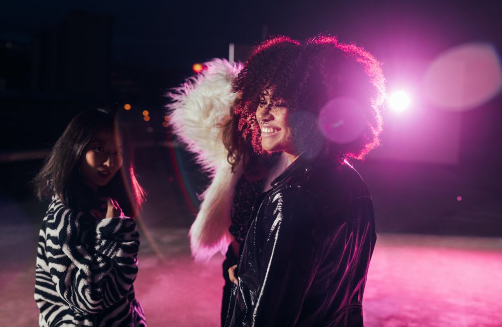 Black woman at a party in pink light
