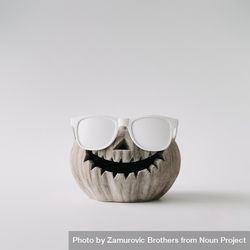 Pumpkin skull with sunglasses on light wall 5rvrp5