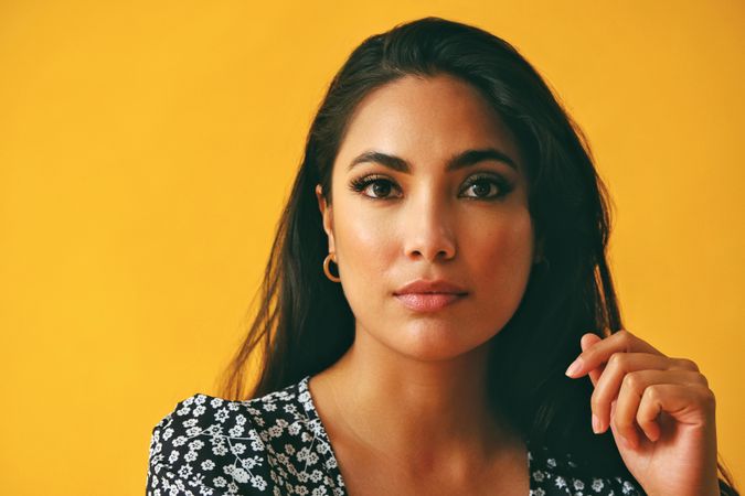 Close up of Hispanic woman wearing dress in yellow room