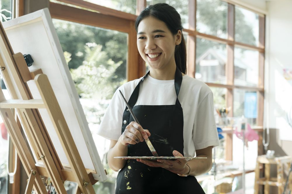 Crafting Inspiration. Female Artist Sketching and Painting in Workshop