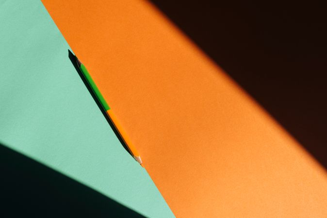 double-ended colored pencil, on light blue and orange background