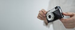 Young man holding retro camera
