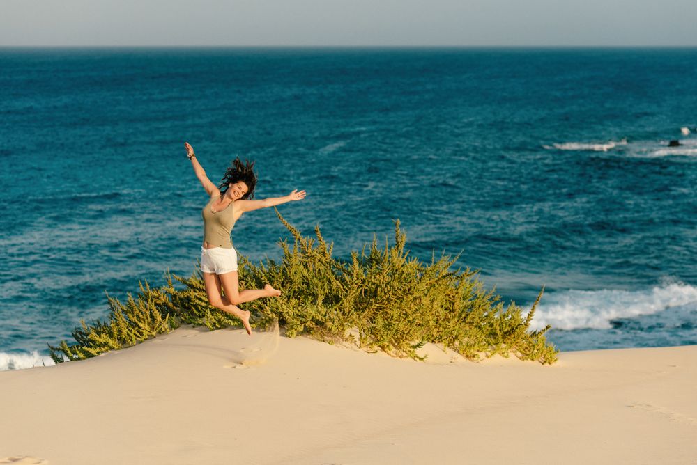 Active woman in white shorts walking sandy beach