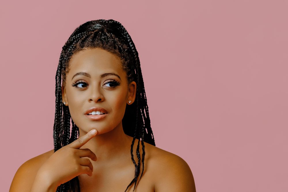 Contemplative female looking at camera in pink studio shoot with copy space