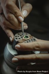 Cropped image of jeweler making a pendant with green gemstone 5qK1ab