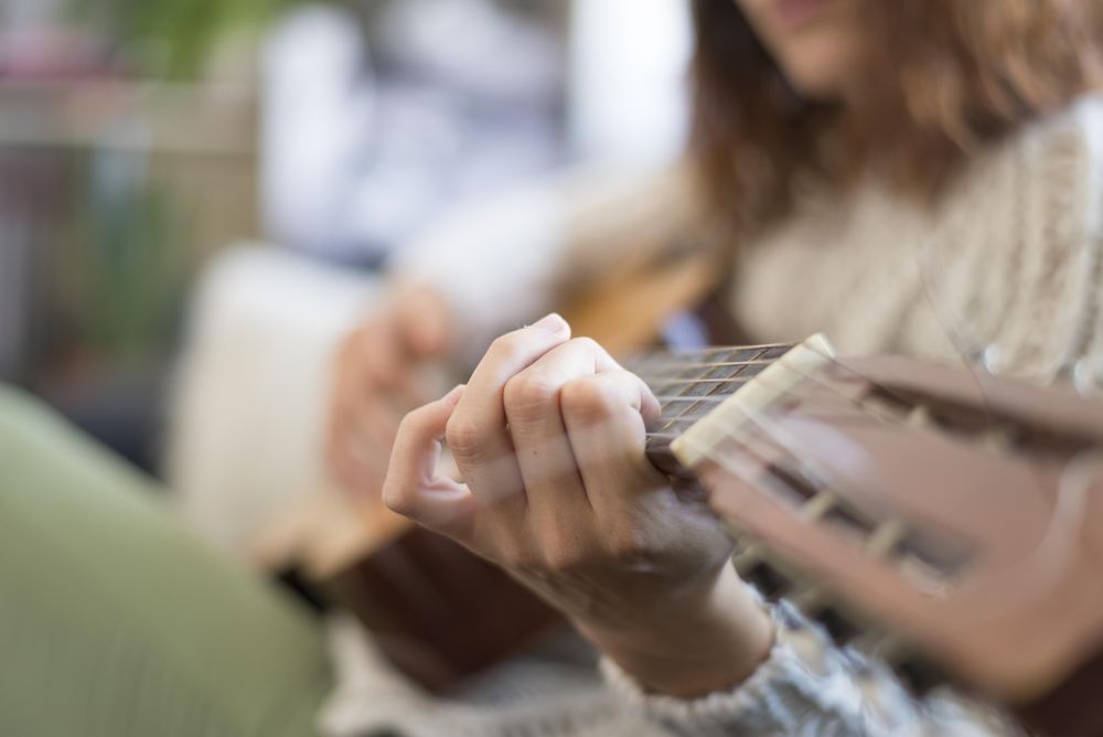 Close up of female hand on fretboard of guitar