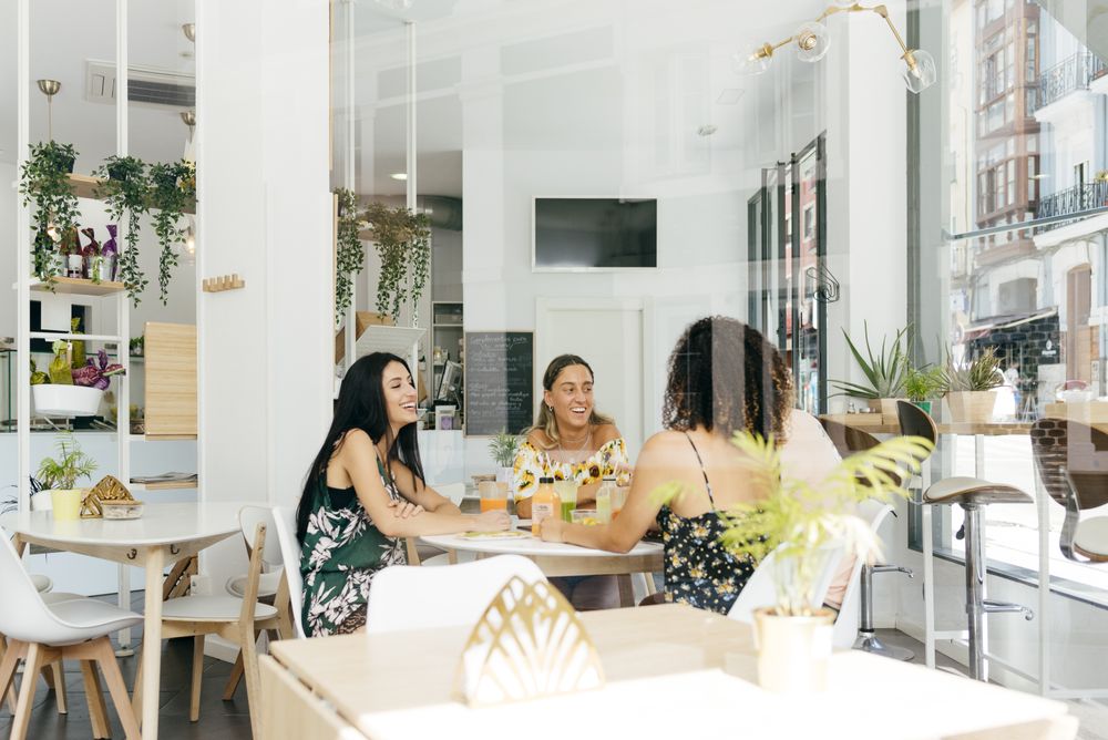 Diverse friends with smoothies sitting in cafe