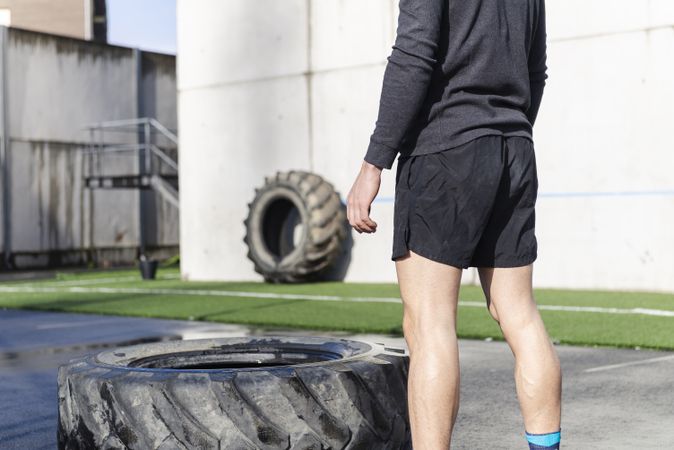 Man training with tire on sports ground