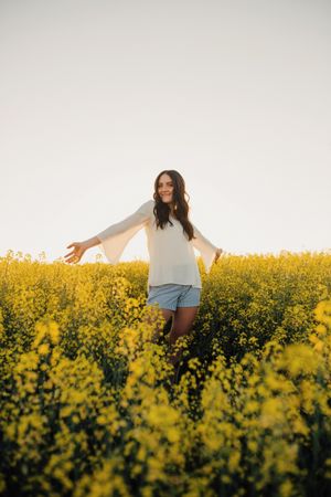 Woman standing on yellow flower field