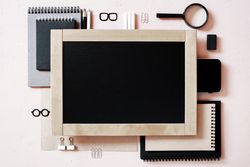 Top view of chalkboard and office supplies with copy space