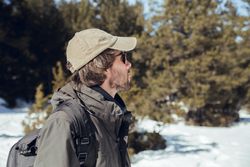 Man between winter forest in sunny day