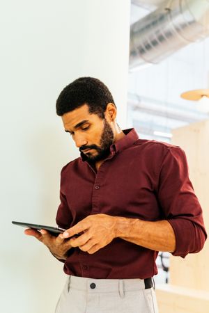 Handsome Latino man working with a tablet in a coworking