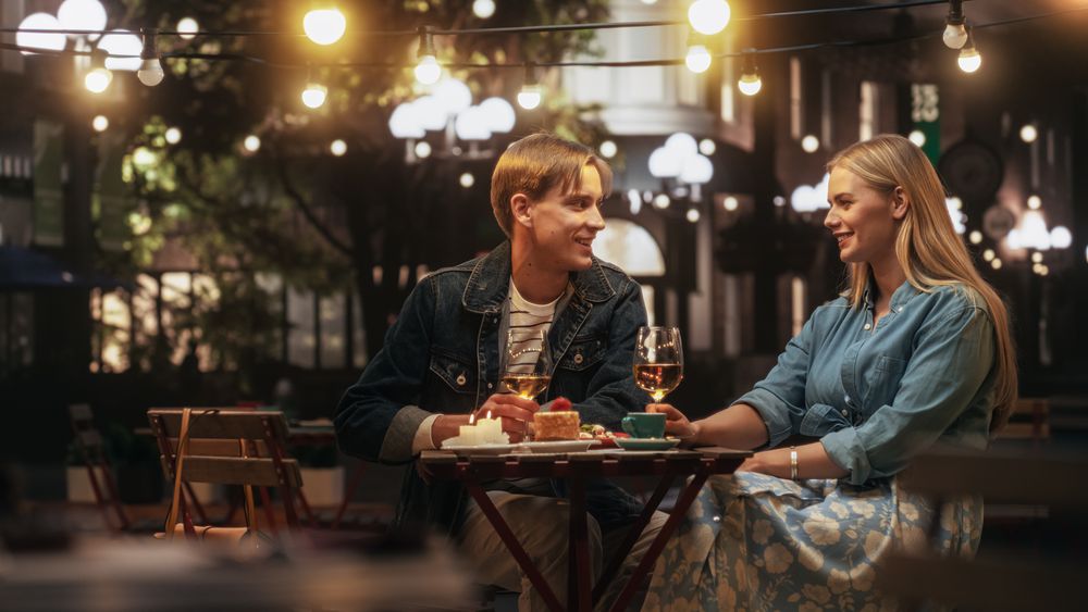 Happy Man and Woman Sitting on a Terrace and Having Fun Conversations During Their Dinner Together in City Center on Weekend