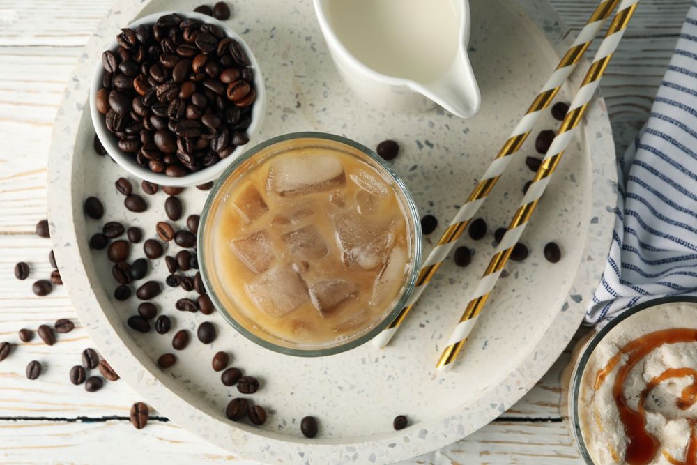 Composition with tray with ice coffee on wooden background