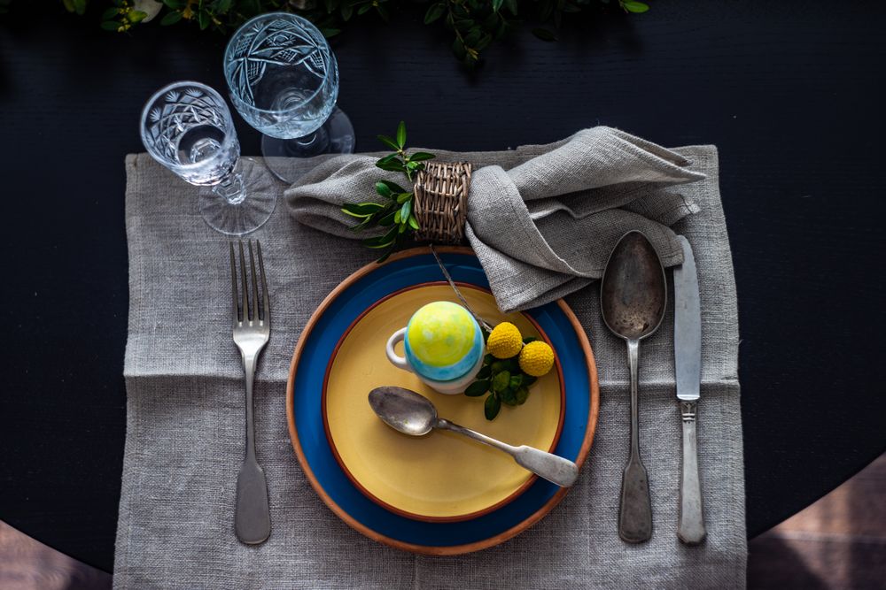Top view of painted egg on plate on elegant table setting