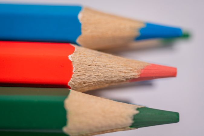 Three pencils with different colors and one of them has a orange tip