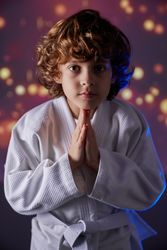 Sportive boy with folded hands during judo training