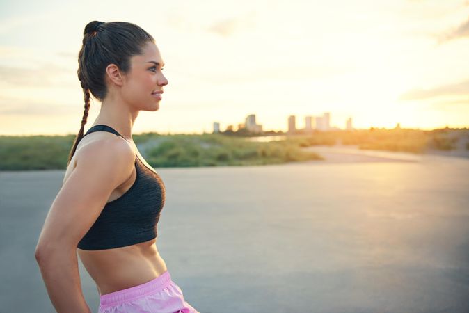 Profile of fit athletic woman with city in distance