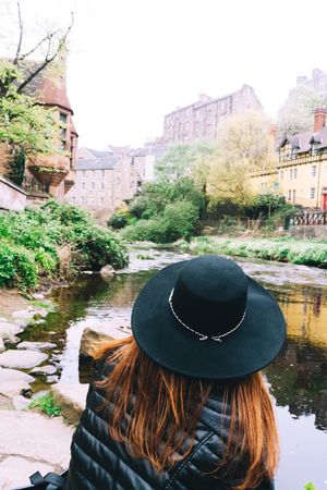 Woman contemplating city aged stone buildings