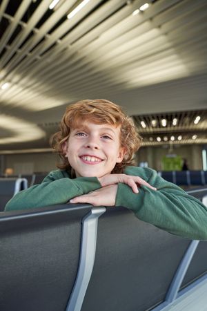Happy boy smiling and sitting on bench