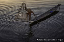 Fisherman standing on boat holding the fishing net in Myanmar 489DZb