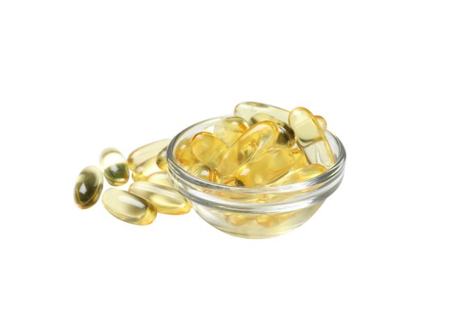 Omega pills in a bowl, isolated on blank background