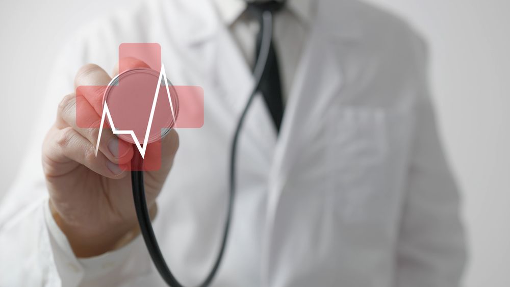 Doctor uses stethoscope with heartbeat hologram