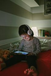 Girl with headphones looking at the tablet