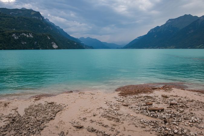 Azure calm sea surrounded by mountains and stony shore