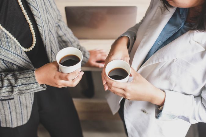 Two businesswomen discussing work over a cup of coffee