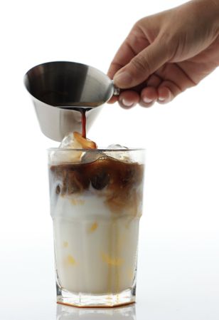 Macro Shot of Pouring Coffee into Milk