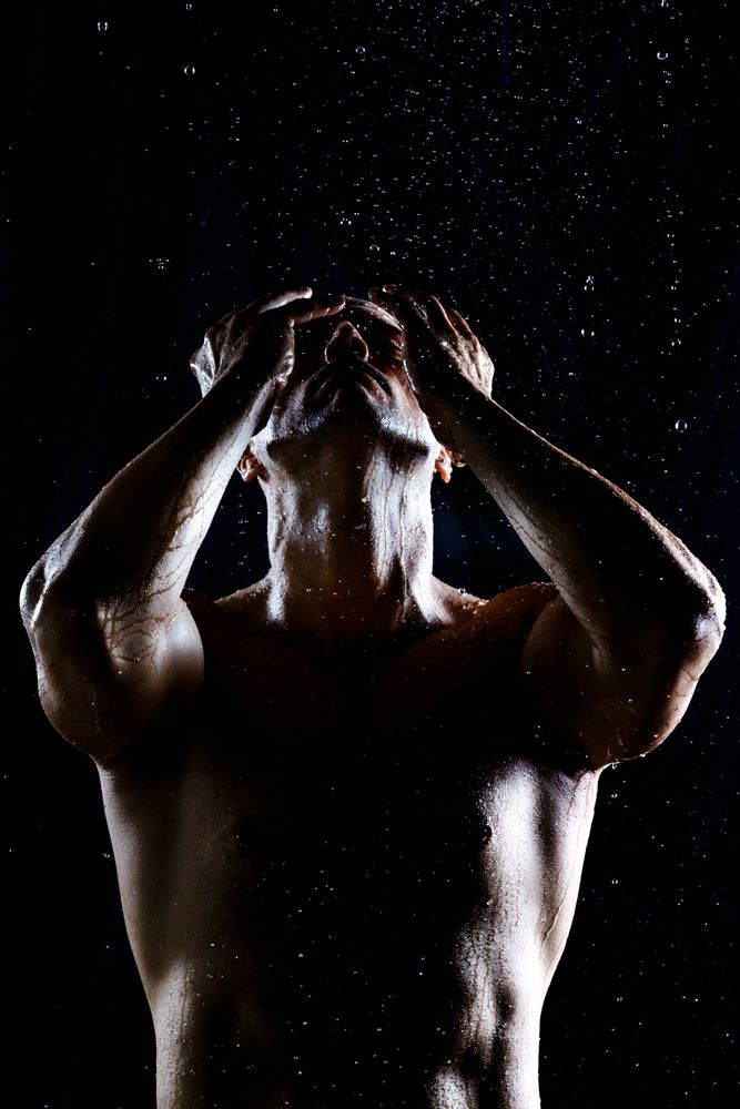 Muscular male under rain