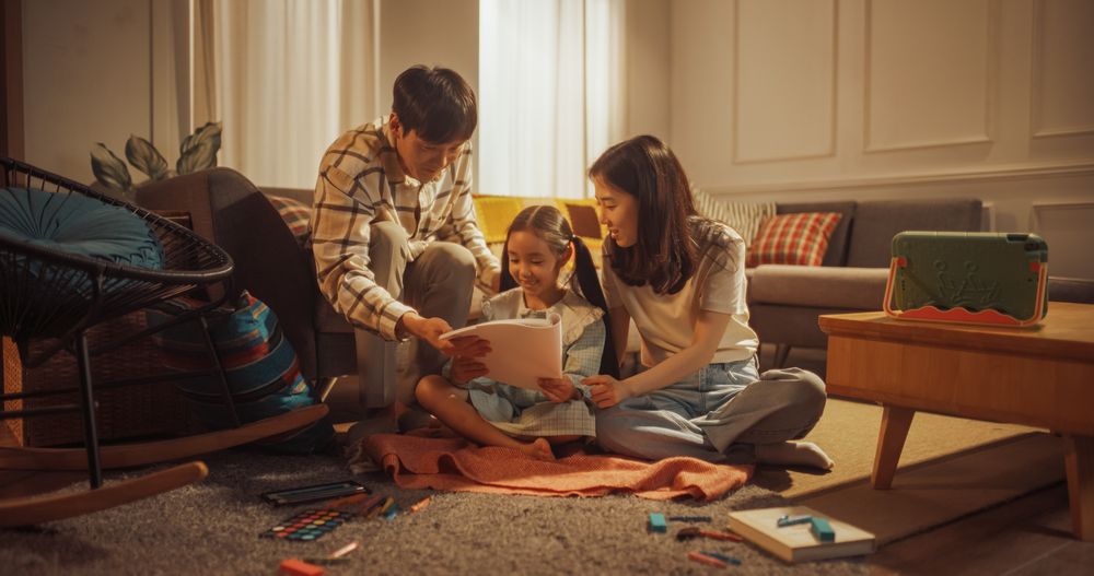 Little Daughter Shows Her Drawings to Happy Father and Mother