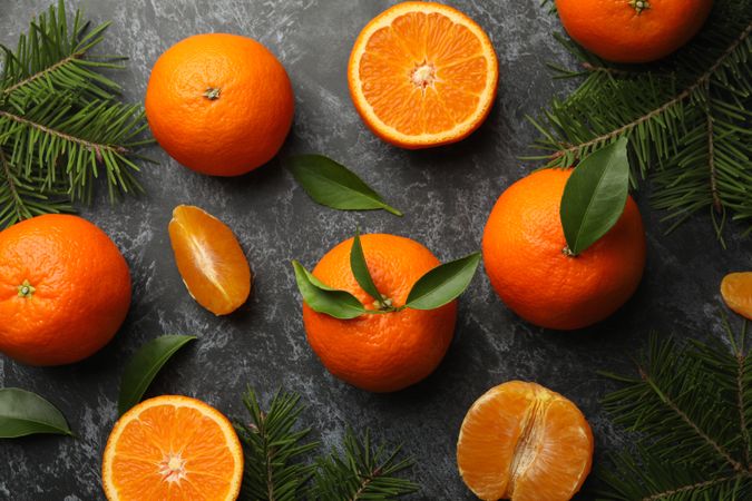 Mandarins and pine branches on gray smoky background