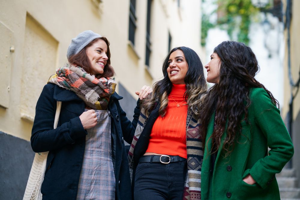 Three women dressed in fall clothes together on a walk