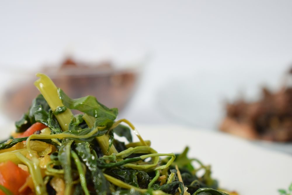 Plate of cooked vegetable side dish on table with copy space