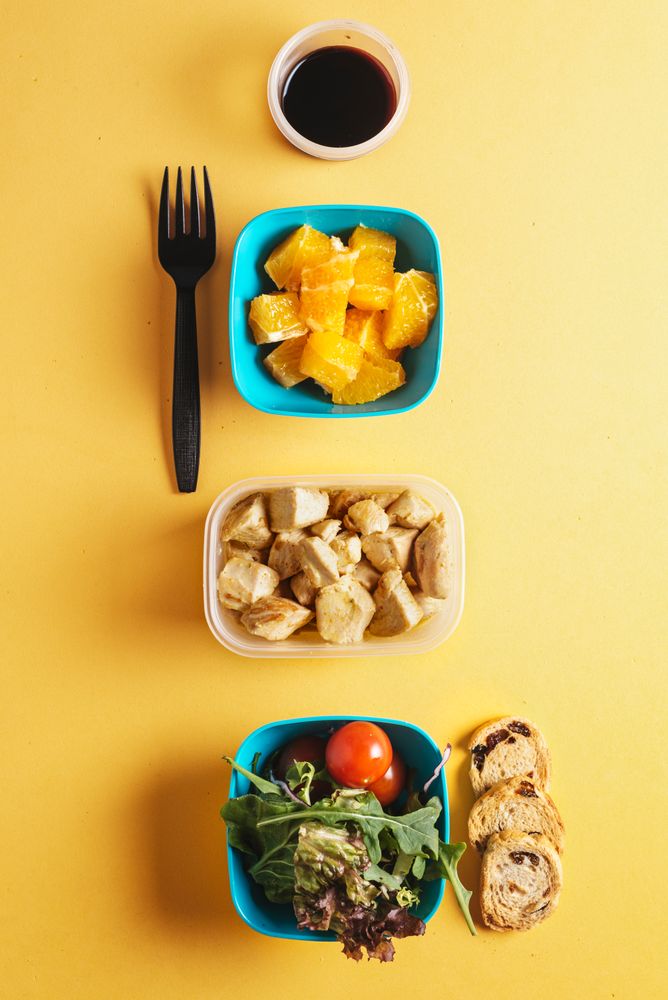 Plastic containers with healthy food and fork