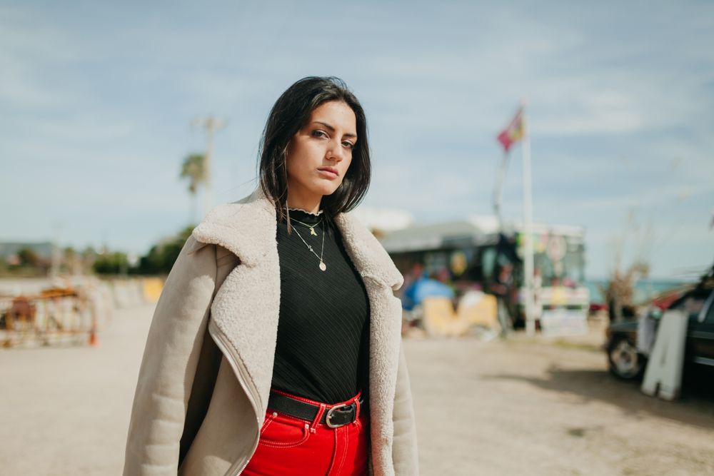 Stylish woman with jacket on beach parking