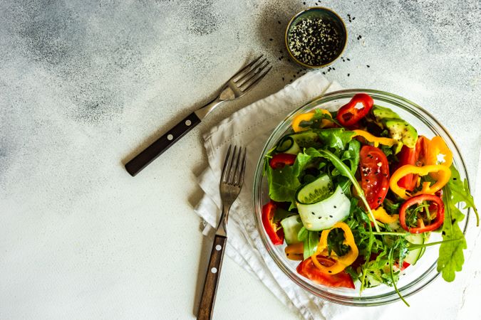 Top view of healthy vegetable salad with arugula and avocado with copy space