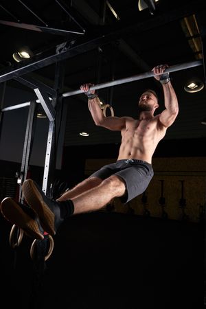 Strong sportsman doing exercise on bar