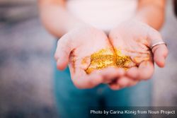 Young woman holding gold glitter o5oQkb