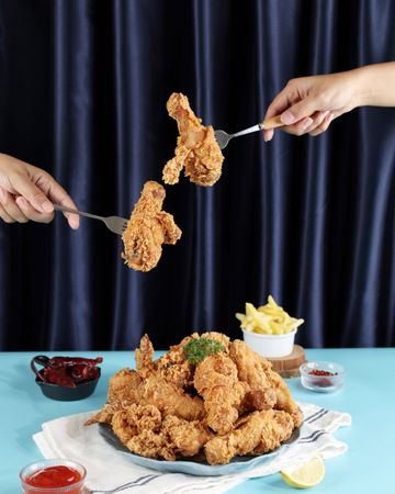 Two Female Hand Woman Hand Taking the Fried Chicken with Fork