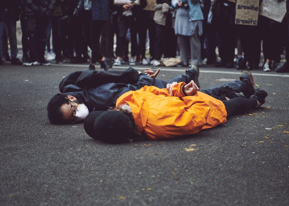 London, England, United Kingdom - June 6th, 2020:  Two men lay on ground with hands behind back