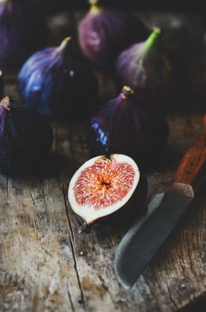 Figs, one halved, on wooden cutting board