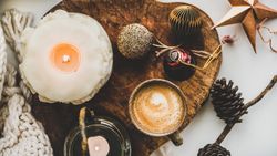 Coffee, candles, festive decorations on wooden board
