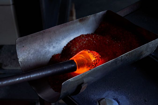 Glassblowing of hot object in workshop